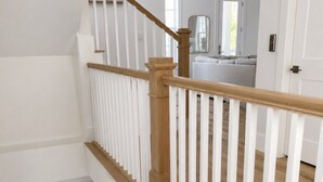A multi-level interior with a wooden staircase and white railings. - Escape to Paradise along the Emerald Coast (Rosemary Beach)
