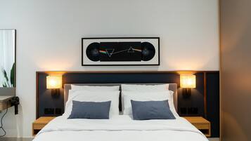 Ein modernes Schlafzimmer mit einem Bett, zwei Nachttischen und einem gerahmten Bild über dem Bett.