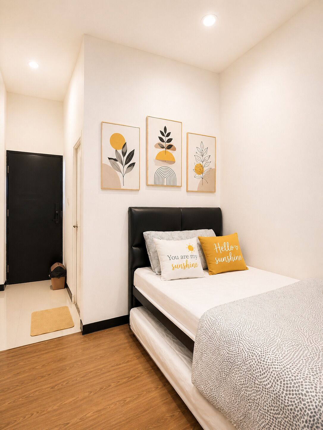 Une chambre à coucher avec un lit, une tête de lit noire et trois œuvres d’art accrochées au mur.