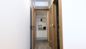 A hallway with wooden doors, a white carpet, and a ceiling light. - Casa Roca do Touro: Mountain View, Wi-Fi & Air Conditioning (Cabril)