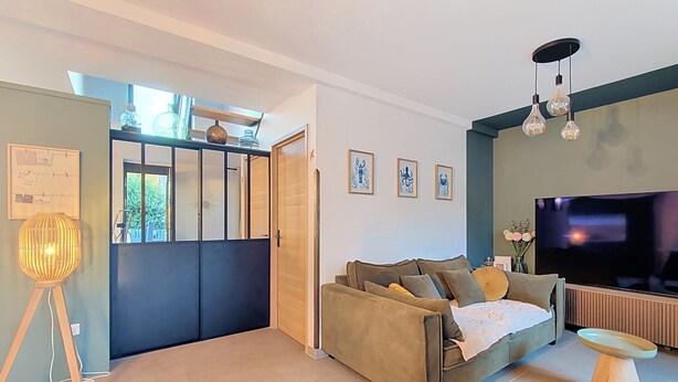 A modern living room with a sofa, a television, and a decorative lamp. - La Maison du Port – Beach within walking distance, peaceful and comfortable (Dives-sur-Mer)