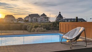 A swimming pool with a chair, surrounded by a wooden deck and a fence. - La Maison du Port – Beach within walking distance, peaceful and comfortable (Dives-sur-Mer)