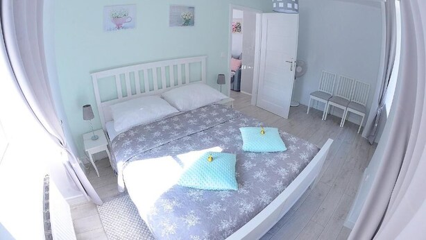 A bedroom with a bed, bedside tables, a wardrobe, and a bench.