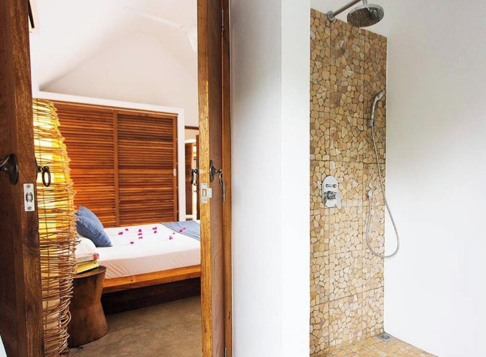 Un dormitorio con cama, armario de madera y lámpara de noche.