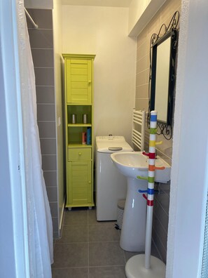 A small bathroom with a toilet, sink, and a green cabinet.