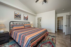 Une chambre à coucher avec un lit, des tables de chevet, une lampe et un tapis.