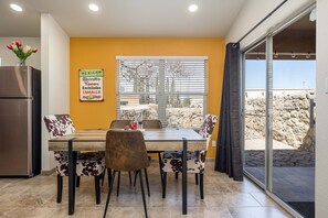 Un espace repas comprenant une table, des chaises et un réfrigérateur.