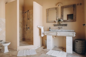 Un baño con ducha, inodoro, lavabo y espejo.