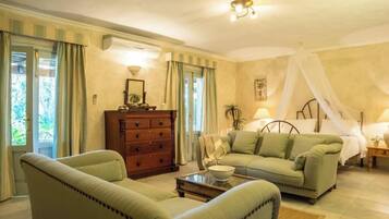 Une pièce comprenant un lit, deux canapés, une commode en bois et une table de chevet.