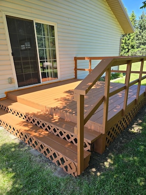 A wooden deck with a ramp leading to a house entrance. - Private Hilltop Oasis with Breathtaking panoramic views. (BISMARCK)