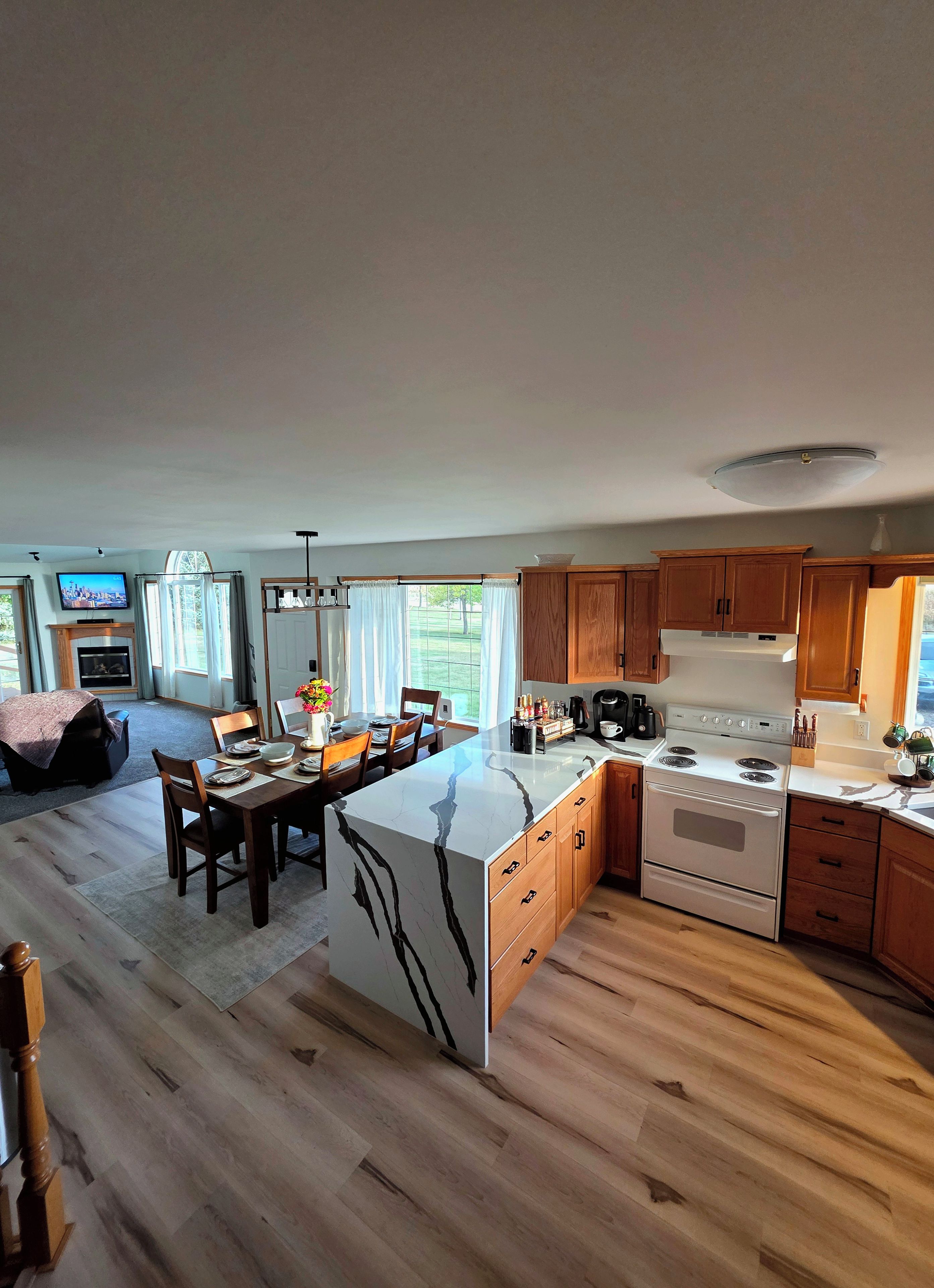 A spacious kitchen with wooden cabinets, a central island, and a built-in oven.