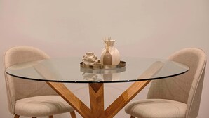 A round glass table with a metal tray, two upholstered chairs, and a decorative vase. - Light & Kozy Residence - Jacuzzi Lux Stay in Patra (Patra)