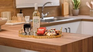 A kitchen counter with a bottle of white wine, a glass, and food items. - Light & Kozy Residence - Jacuzzi Lux Stay in Patra (Patra)