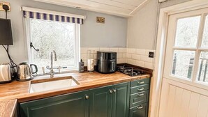 A compact kitchen with a sink, stove, and cabinets.
