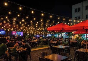 An outdoor dining area with string lights and tables. - Charming 2-bedroom Apartment in Santo Domingo Este (Santo Domingo Este)