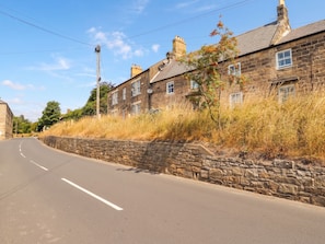 Eine ruhige Straße mit Steinmauern und traditionellen Häusern.
