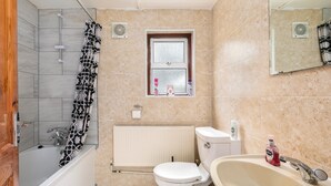 Ein Badezimmer mit Dusche, Toilette und Waschbecken.