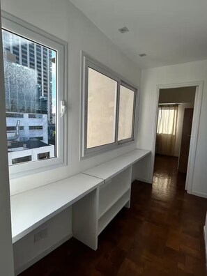 Ein Zimmer mit einer fest eingebauten Sitzbank an der Wand, großen Fenstern und Blick ins Freie.