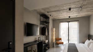 A modern hotel room with a bed, desk, and TV. - Ross Street Hotel (San Ġiljan)