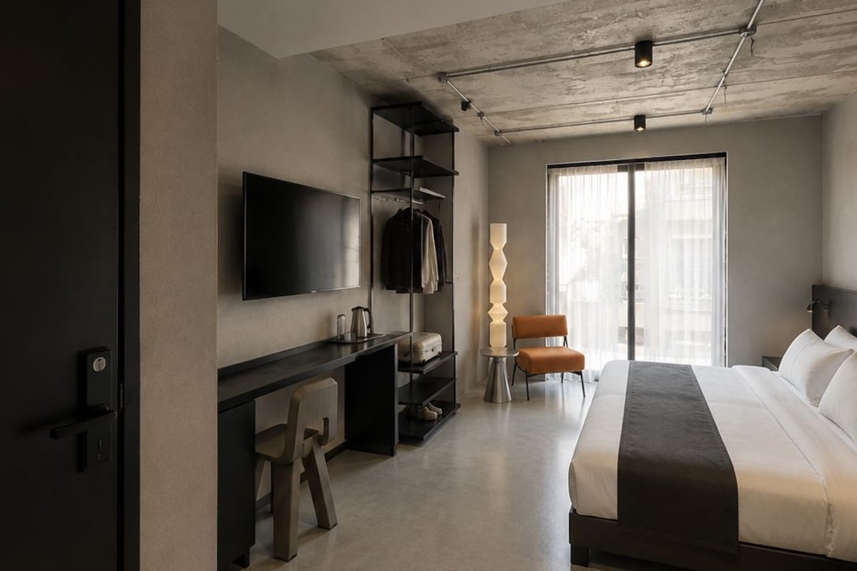 Una habitación de hotel moderna con cama, escritorio y televisión.