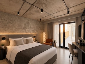 Una habitación de hotel moderna con una cama grande, un escritorio y una televisión.