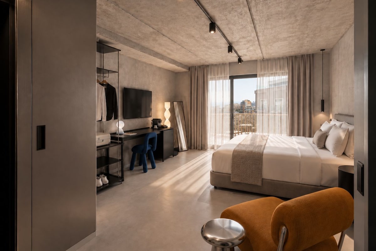 Una habitación de hotel moderna con una cama grande, un escritorio, un televisor y vistas a la ciudad.