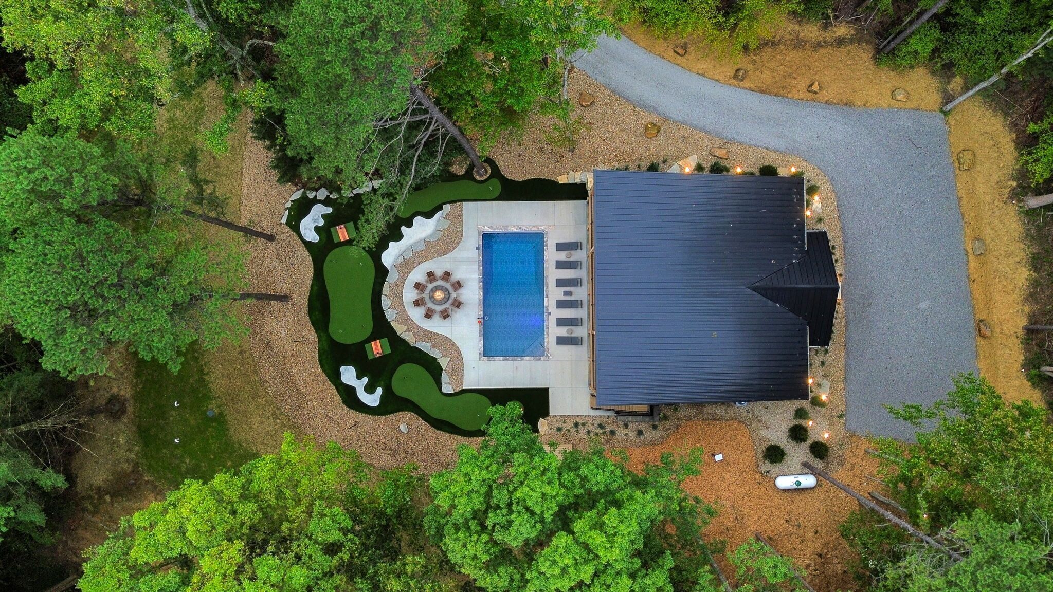 A residential property with a swimming pool, patio, and a covered outdoor area.