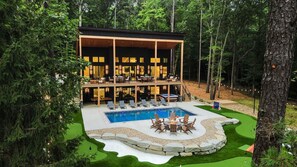 A two-story building with a pool and outdoor seating. - The Rock Haus | Pool, Putt-Putt | Hocking Hills (Laurelville)