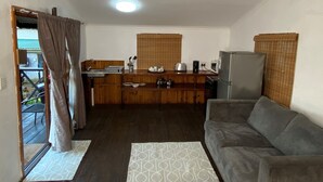 A compact living space with a kitchenette, a sofa, and a dining area.