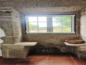 A stone bench with a window, a basket, and a tiled floor. - Picturesque Villa with Private Pool by Interhome (Alvite)