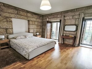 A bedroom with a large bed, a nightstand, a dresser, a mirror, and a window with curtains. - Picturesque Villa with Private Pool by Interhome (Alvite)