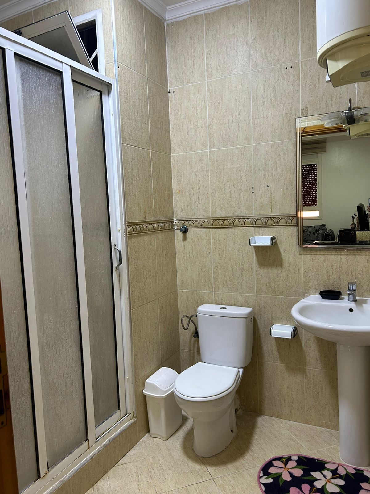 Un baño con inodoro, lavabo y cabina de ducha.