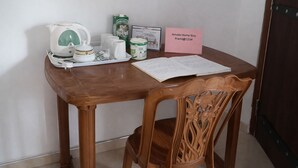 Una mesa de madera con una bandeja que contiene una tetera, tazas y un letrero con un nombre y un número de teléfono.