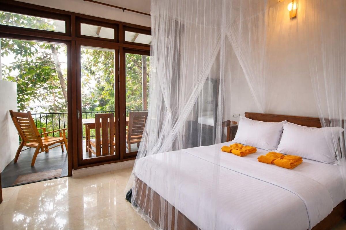 A bedroom with a bed, a chair, and a table.