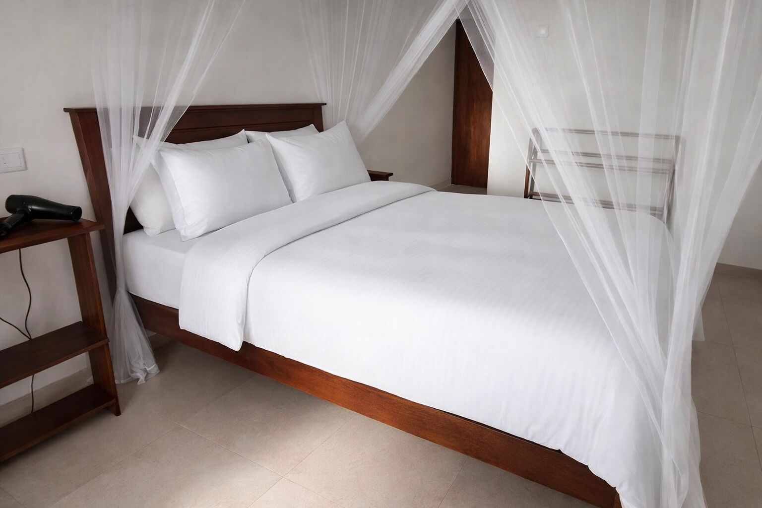 A bed with a canopy, a bedside table, and a power outlet.
