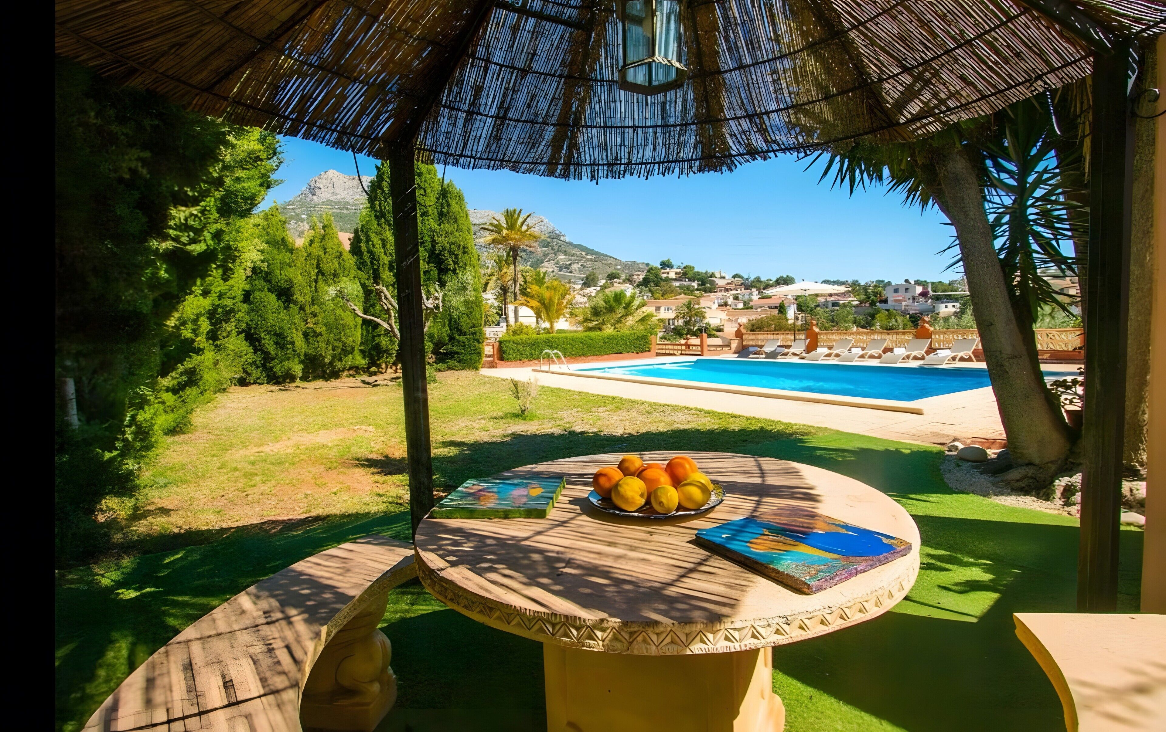 Ein Außenbereich mit Sitzgelegenheit, einem Pool und Blick auf eine Wohngegend.