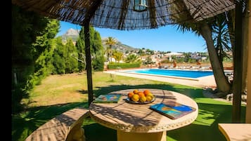 Ein Außenbereich mit Sitzgelegenheit, einem Pool und Blick auf eine Wohngegend.