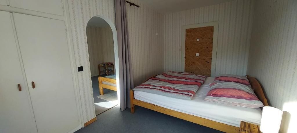 Ein Schlafzimmer mit Bett, Kleiderschrank und einem kleinen Tisch.