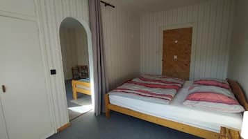 Ein Schlafzimmer mit Bett, Kleiderschrank und einem kleinen Tisch.