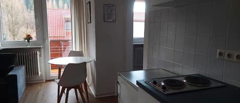 Una cocina funcional con una mesa, una silla y una estufa.