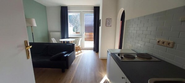 A compact living space with a kitchenette, a dining area, and a view of the outside.