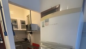 Eine kompakte Küche mit Kühlschrank, Mikrowelle und Spüle.