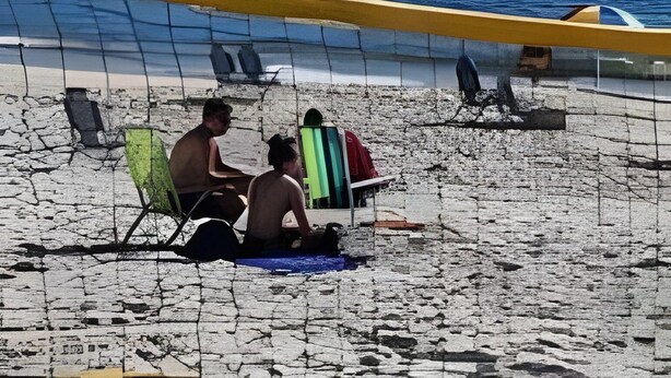 A beach volleyball court with players and a net, a mountain in the background, and a cityscape across the water. - Studio Pé na Areia em Copacabana (Rio de Janeiro)