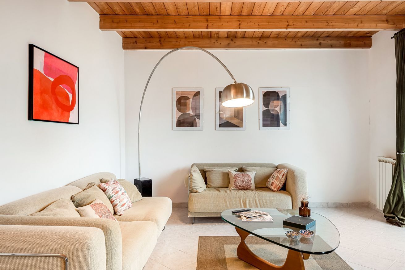 A living room with two sofas, a glass coffee table, and a floor lamp.