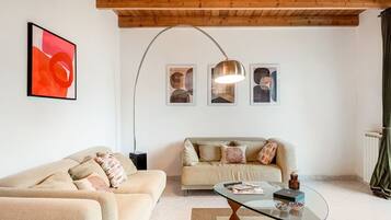 A living room with two sofas, a glass coffee table, and a floor lamp.