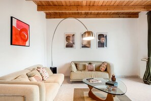 Ein Wohnzimmer mit zwei Sofas, einem Glastisch und einer Stehlampe.