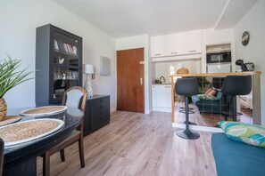 A modern living room with a dining area, a kitchen, and a small office space. - Cocon d'Ax - Station de ski accessible à pied (Ax-les-Thermes)