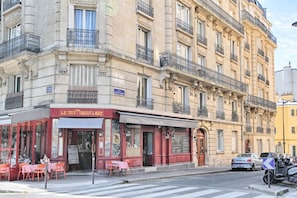 A building with a restaurant named 'Le Matin Salat' on the ground floor, featuring outdoor seating with tables and chairs. - Appartement Parisien Haussmannien Ethnique (Paris)