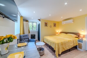 Een slaapkamer met een bed, nachtkastje, lamp en een raam met gordijnen.