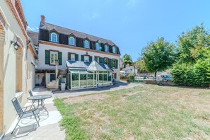 Ein zweigeschossiges Gebäude mit Wintergarten, Außenbereich und einem grünen Innenhof.